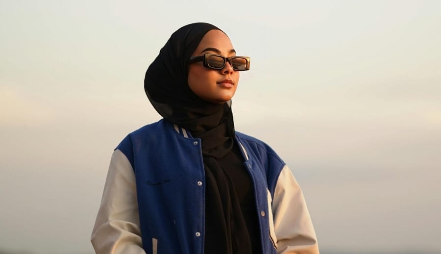Jaket varsity yang digunakan oleh wanita berhijab.